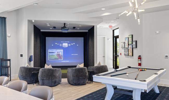 a room with a pool table and chairs