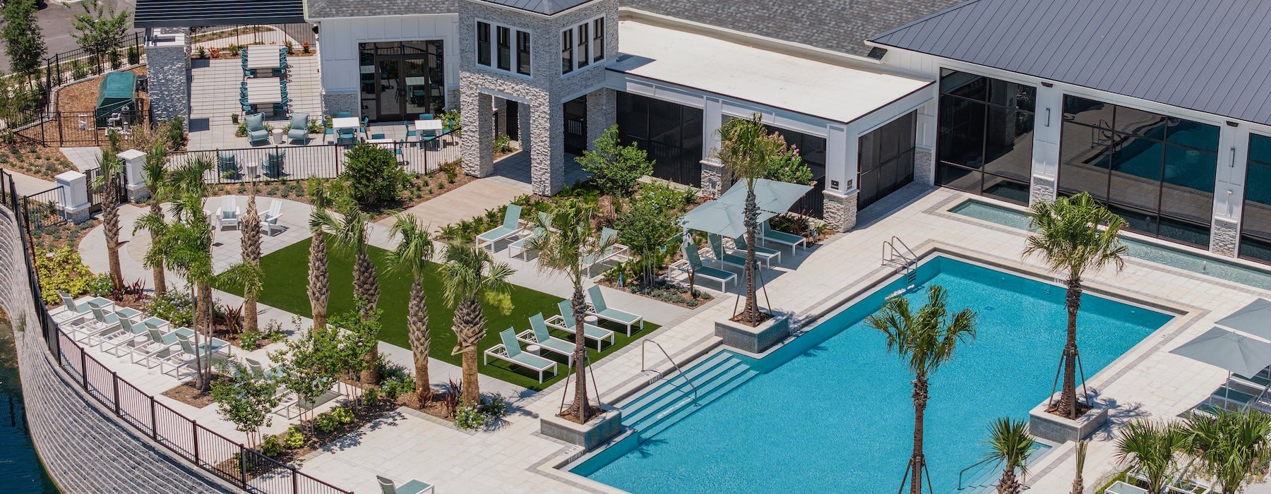 a building with a pool and palm trees